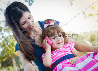 Mother and Cute Baby Daughter Playing with Cell Phone