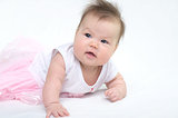 Newborn baby in pink dress smiling