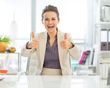 Smiling business woman showing thumbs up