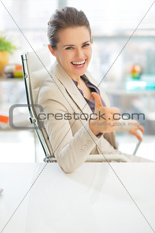 Happy business woman showing thumbs up
