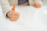 Closeup on business woman showing thumbs up