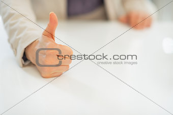 Closeup on business woman showing thumbs up
