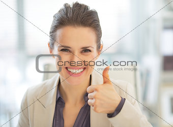 Portrait of happy business woman showing thumbs up