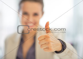 Closeup on smiling business woman showing thumbs up