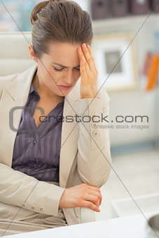 Stressed business woman with head ache at work