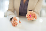 Closeup on business woman showing pills