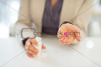 Closeup on business woman showing pills