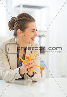 Laughing business woman holding pencils