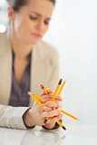 Closeup on thoughtful business woman holding pencils