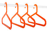 Orange hangers on a rod isolated on white
