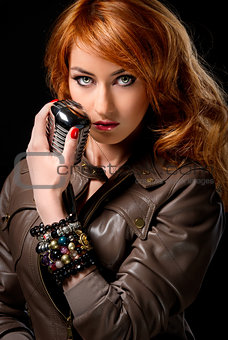 Beautiful redhead girl with retro microphone