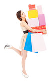 smiling young woman holding gift box and shopping bag