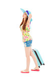 young female styled in summer outfit with travel baggage