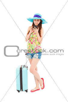 happy woman looking the smart phone with  travel baggage