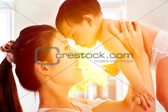 Happy  mother holding adorable child baby with sunrise backgroun
