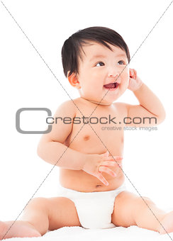 smiling Infant child baby sitting and look up