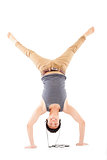 young man doing a handstand against and listening music