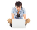 Young man sitting on floor and using a laptop