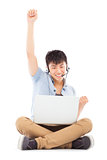 successful Young man sitting on floor and using a laptop