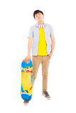 full length of a young man standing and holding a skateboard