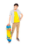 confident young man standing and holding a skateboard