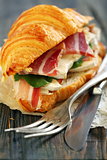 Croissant with ham and cheese close up.