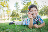 Young Boy Enjoying His Lollipop Outdoors Laying on Grass