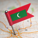 Maldives Small Flag on a Map Background.