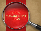 Debt Management Plan. Magnifying Glass on Old Paper.