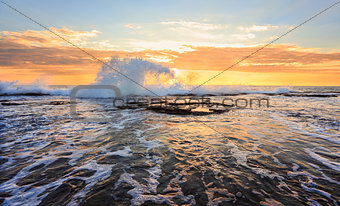 Sunrise seascape splash in the shape of a wave