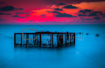 Seascape and Empty Cage at Colorful Sunset