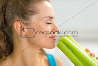 Portrait of young woman smelling fresh celery