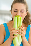Portrait of young woman smelling fresh celery