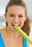 Portrait of young woman tasting fresh celery