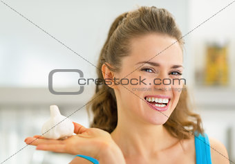 Portrait of happy young woman showing garlic