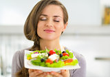 Portrait of young housewife enjoying fresh salad