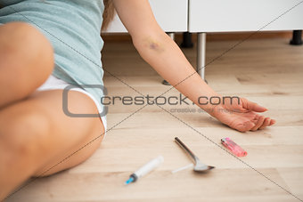 Closeup on syringe spoon and lighter and drug addict young woman