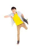 Vibrant young man holding a skateboard and make a pose