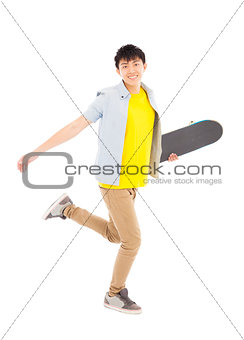 Vibrant young man holding a skateboard and walking 
