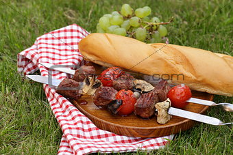 meat roasted on the fire skewers (shashlik) with tomatoes and mushrooms