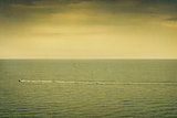 Sunset at sea. Sailboat. Seascape. retro colors, paper grain