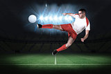 Fit football player playing and kicking