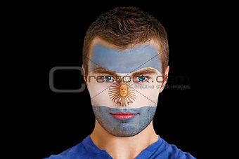 Serious young argentina fan with facepaint