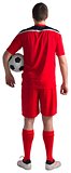 Football player wearing red gear standing with ball