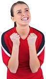 Excited football fan in red cheering