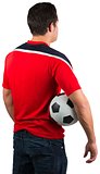 Football fan in red jersey holding ball