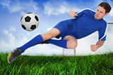 Football player in blue kicking the ball
