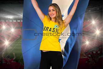 Excited football fan in brasil tshirt holding honduras flag