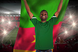 Cheering football fan in green jersey holding cameroon flag