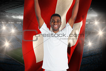 Excited handsome football fan cheering holding swiss flag